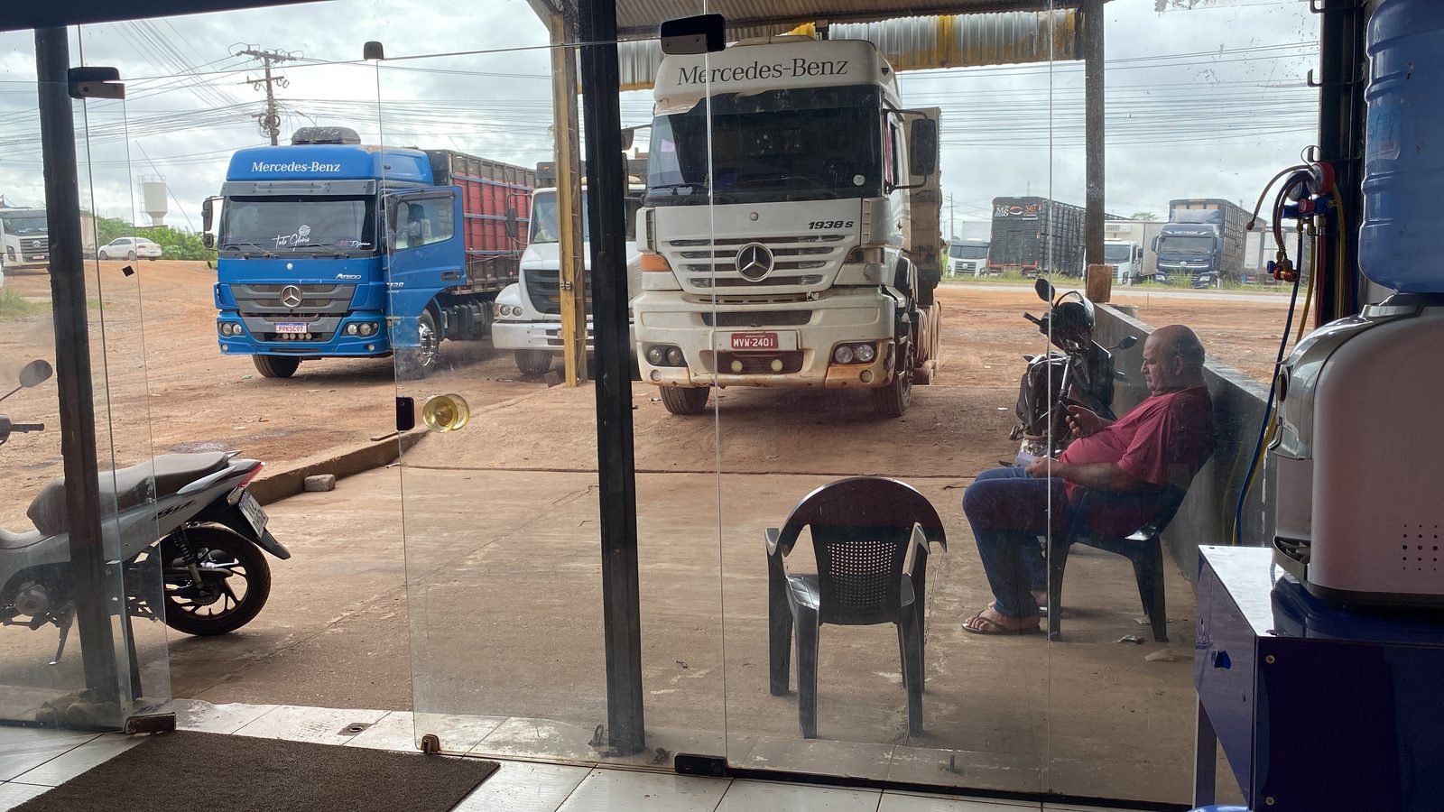 Área interna da oficina Dr Diesel com caminhões no pátio